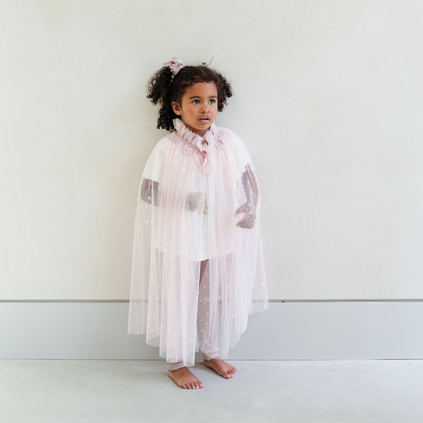 girl wearing a pink shimmer tulle dressing up cape