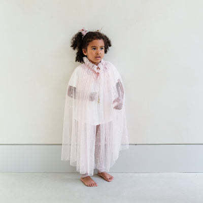girl wearing a pink shimmer tulle dressing up cape