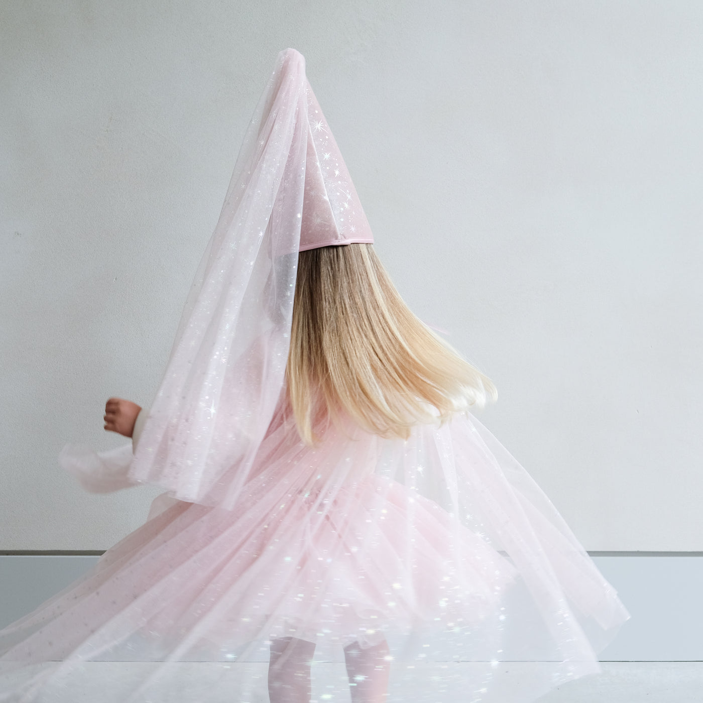 girl wearing a pink shimmer tulle dressing up cape
