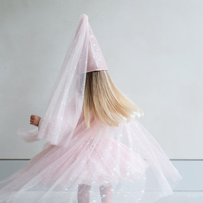 girl wearing a pink shimmer tulle dressing up cape