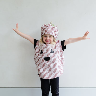 Child wearing a pumpkin costume with black accents against a plain background