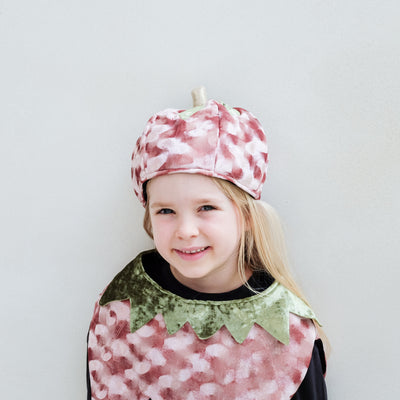 Child wearing a pumpkin costume and hat with a white background