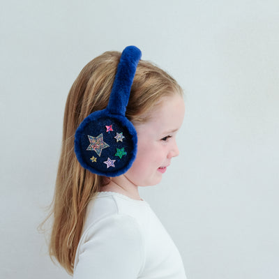 Child wearing navy earmuffs with star designs on a white background