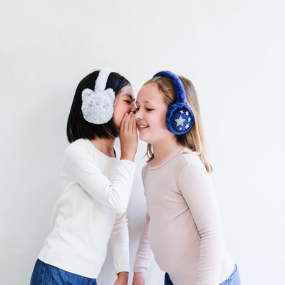Two children wearing colourful earmuffs against a white background