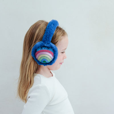 Child wearing blue rainbow earmuffs with a colourful applique on a white background