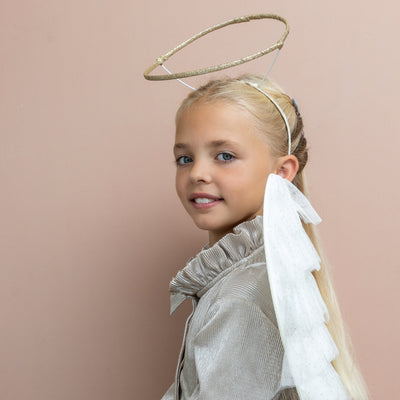 Blonde girl wearing gold glitter halo and tulle angel wings