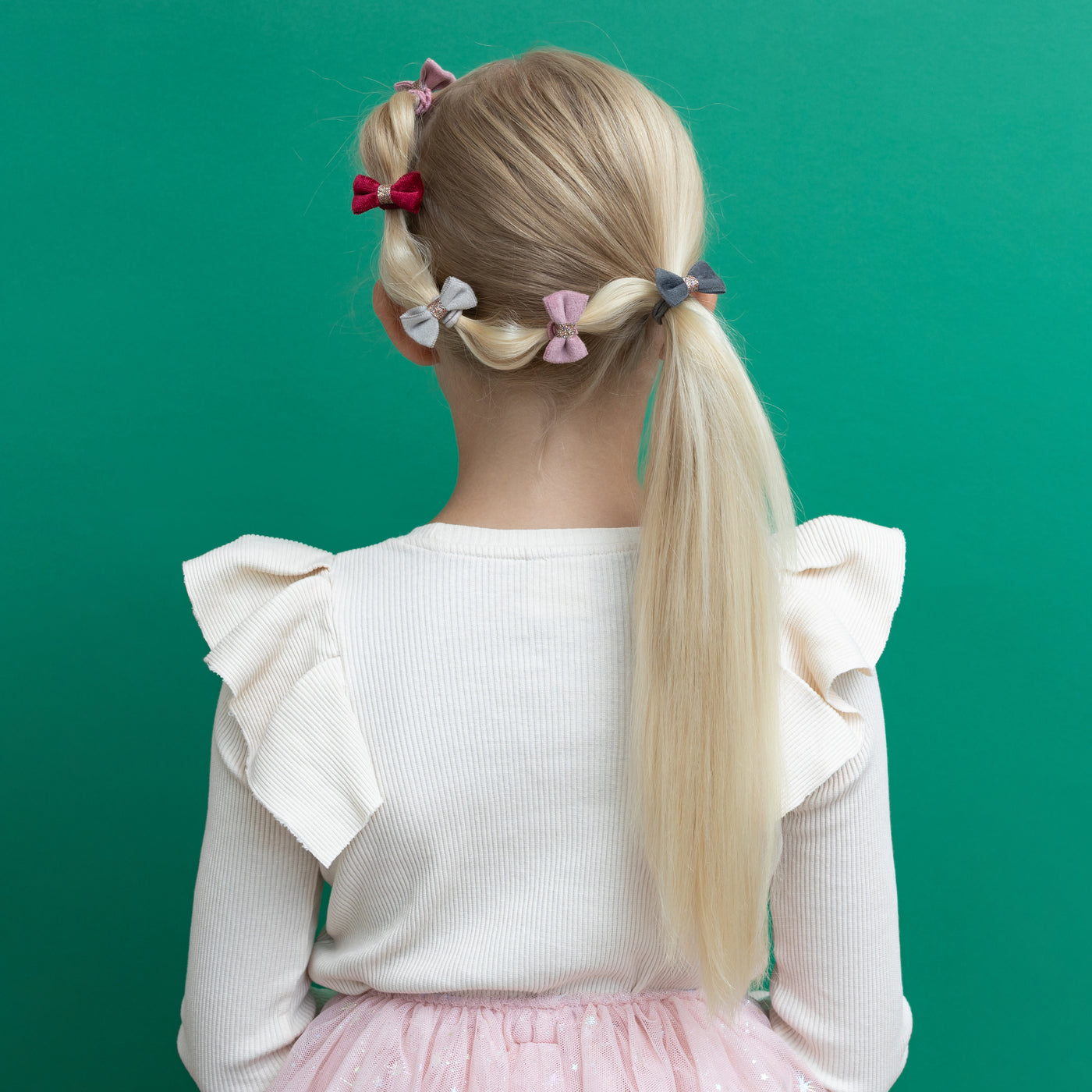 Blonde girl with fancy ponytail decorated with mini velvet bow clips