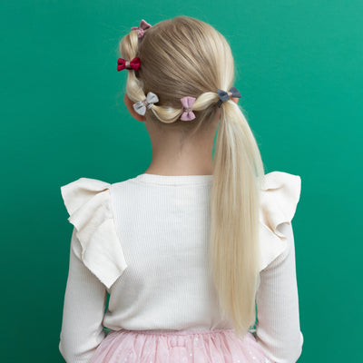Blonde girl with fancy ponytail decorated with mini velvet bow clips