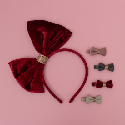 Large oversize red velvet bow alice band on pink background with four velvet bow mini hair clips