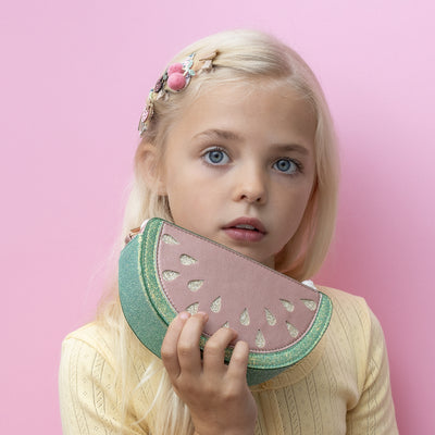 Blonde little girl holding a 3D watermelon shaped handbag 