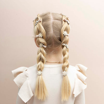 Two braids decorated with daisy hair clips and hair bands