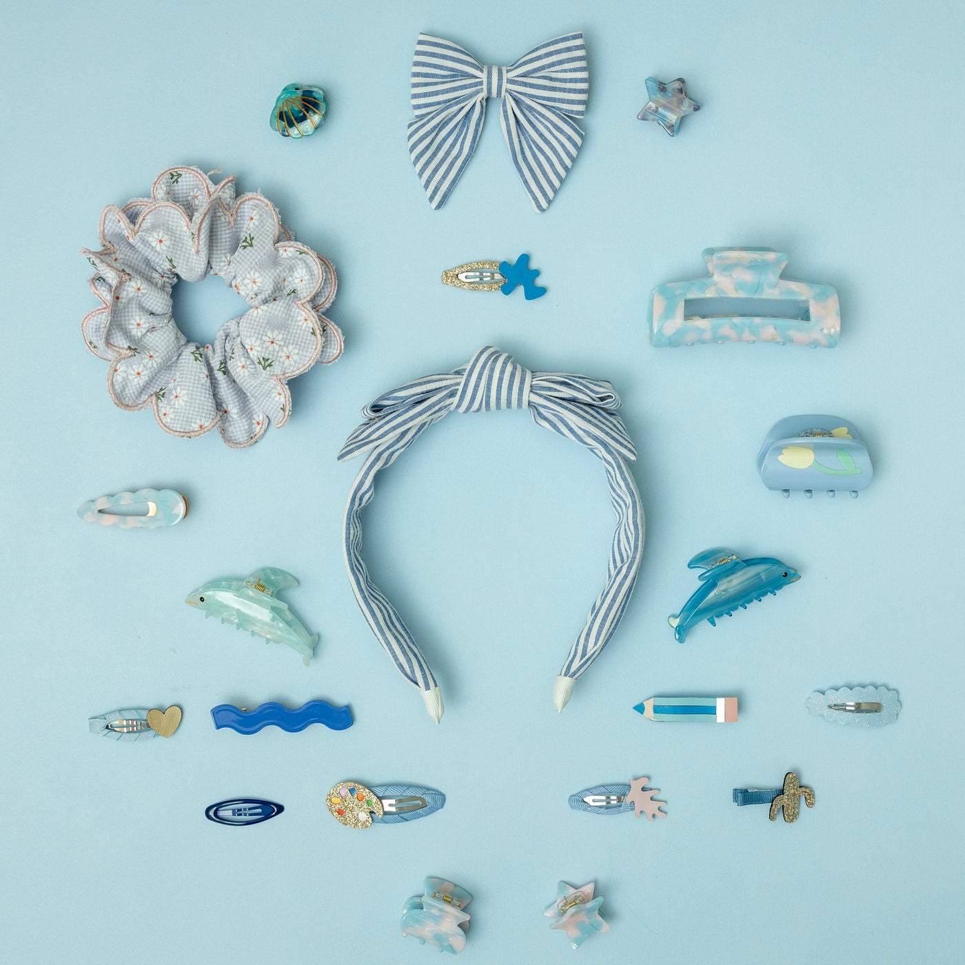 A selection of blue hair accessories laid on a blue background