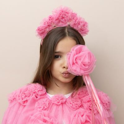 Dark haired little girl wearing a bright pink ruffle flower tulle cape with matching headband and tulle flower wand with ribbons 