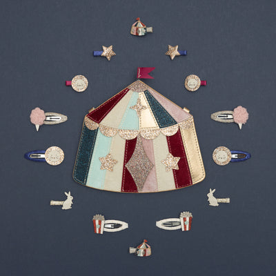 Sparkly circus themed clips, surrounding circus tent bag, on dark blue background