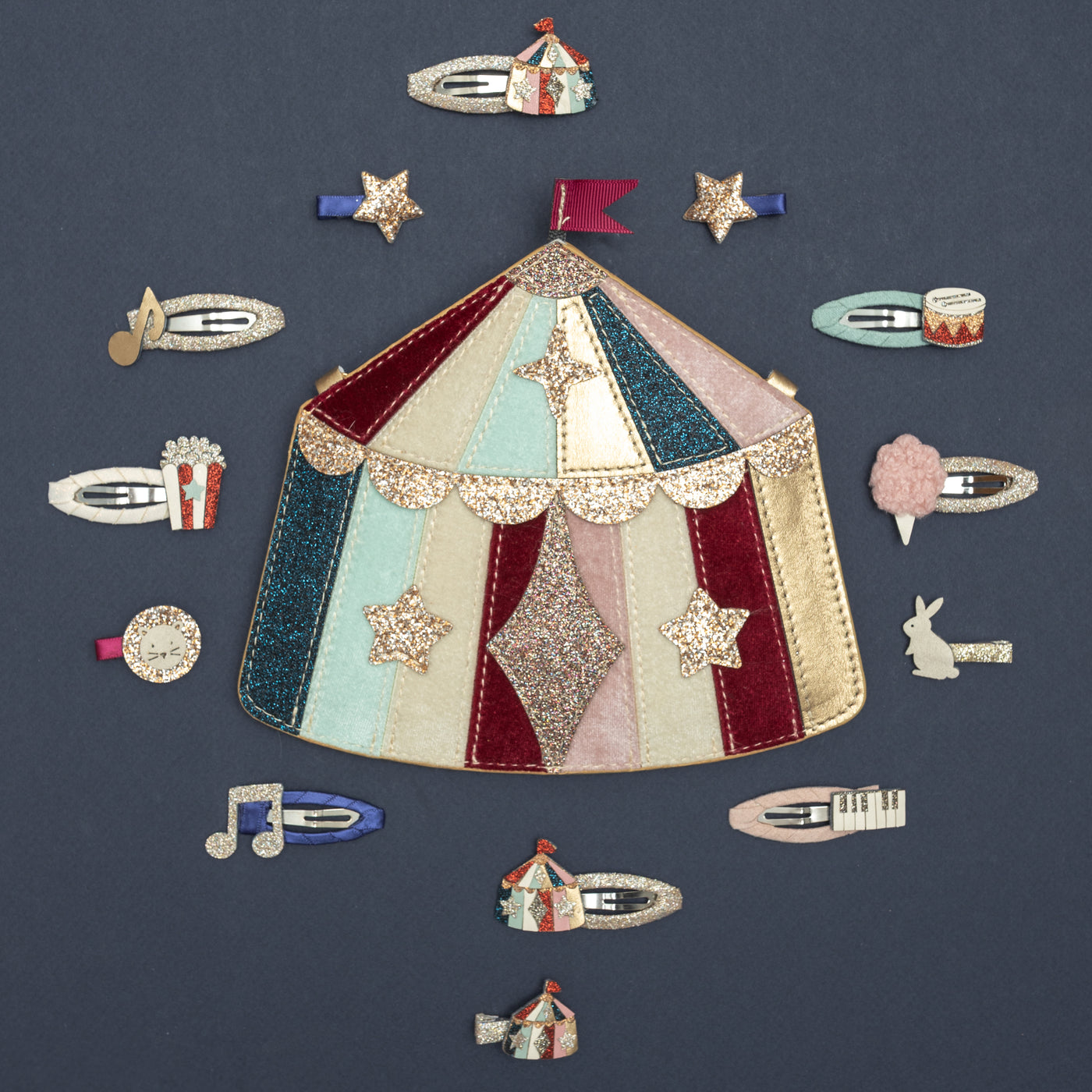 Sparkly circus themed clips, surrounding circus tent bag, on dark blue background