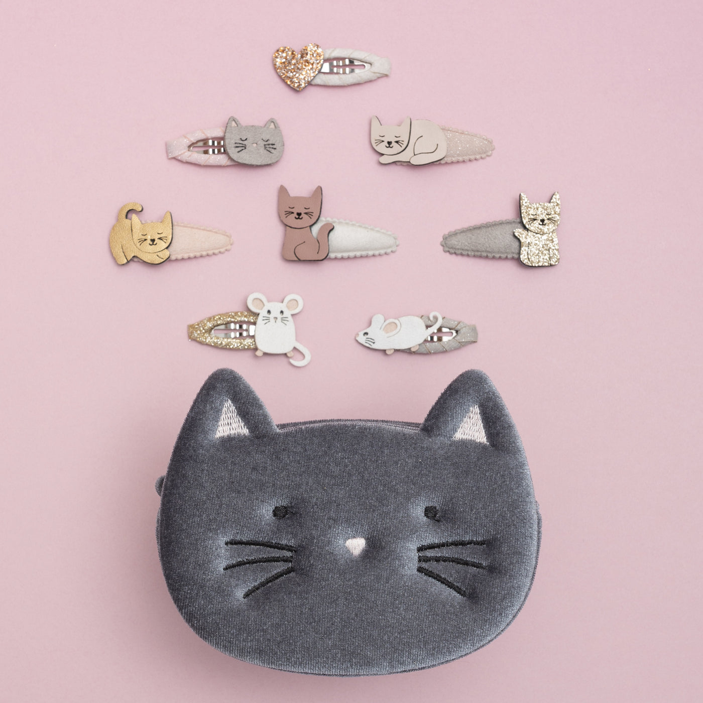 Soft grey velvet kitty cat bag, surrounded by cute cat themed clips, on a pink background