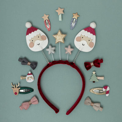 A glittery Santa bopper headband takes centre stage, surrounded by a festive collection of Christmas-themed hair clips