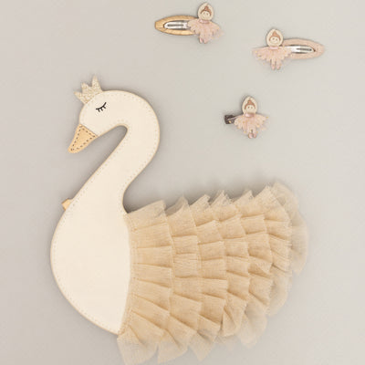 Swan shaped elegant children's handbag with ballerina hair clips laid above