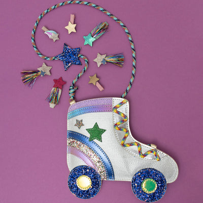 A dazzling glittery roller skate crossbody bag, shimmering with metallic sparkles and retro details like wheels and laces, surrounded by a collection of disco-themed hair clips, creating a fun, party-ready vibe