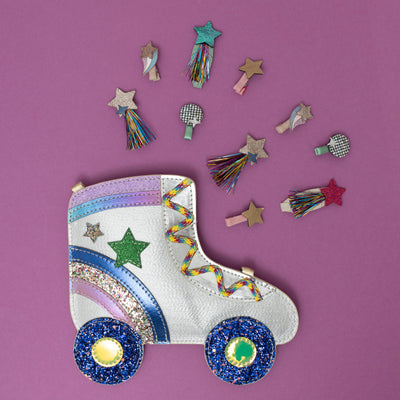 A dazzling glittery roller skate crossbody bag, shimmering with metallic sparkles and retro details like wheels and laces, surrounded by a collection of disco-themed hair clips, creating a fun, party-ready vibe