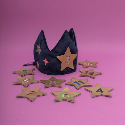 Navy velvet crown sat on a purple background surrounded by gold metallic numbered stars to celebrate birthdays from age 3 to 12 years