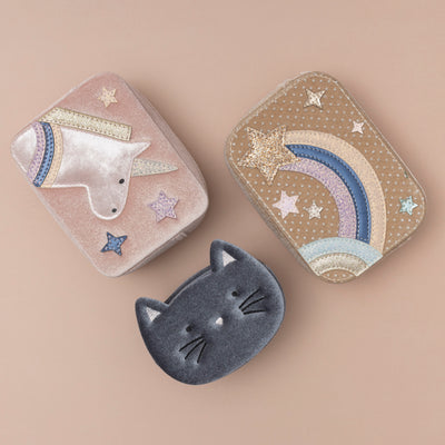 A trio of charming bags: a soft grey velvet kitty cat bag, a blush pink velvet unicorn box bag, and a beige celestial star velvet bag, each showcasing a unique blend of colours and textures
