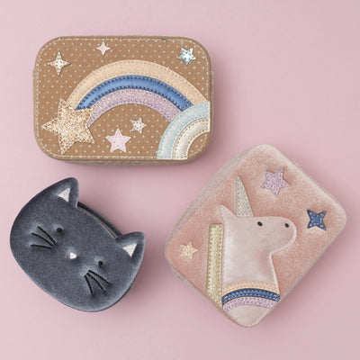 A trio of charming bags: a soft grey velvet kitty cat bag, a blush pink velvet unicorn box bag, and a beige celestial star velvet bag, each showcasing a unique blend of colours and textures, set against a soft pink background