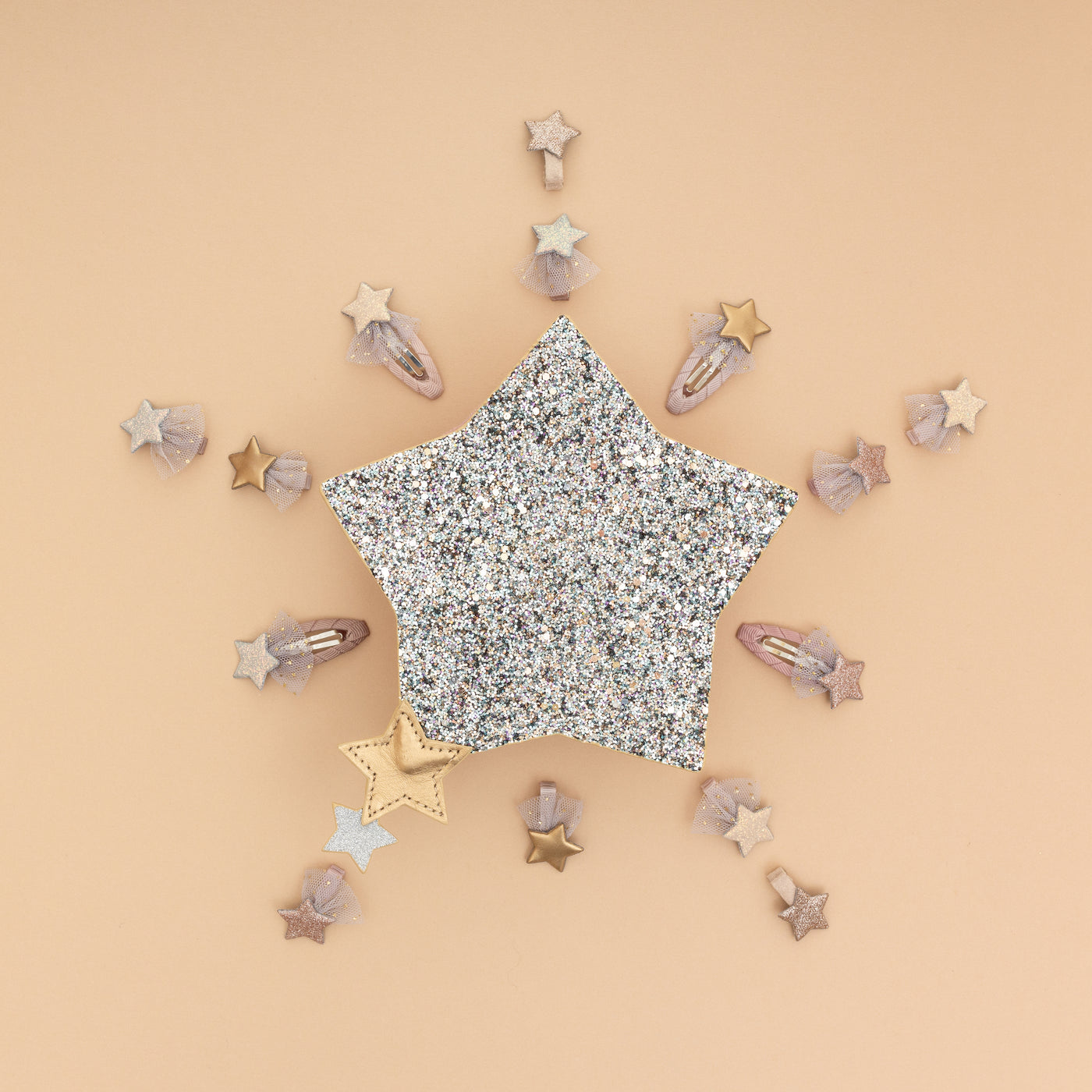 Beautiful 3D sparkly glitter star shaped bag on a pale peach background with lots of little star hair clips