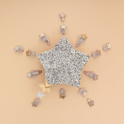 Beautiful 3D sparkly glitter star shaped bag on a pale peach background with lots of little star hair clips