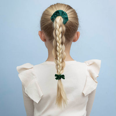 blonde girl wearing Assorted school pack bow clips and scrunchie in green against a blue background