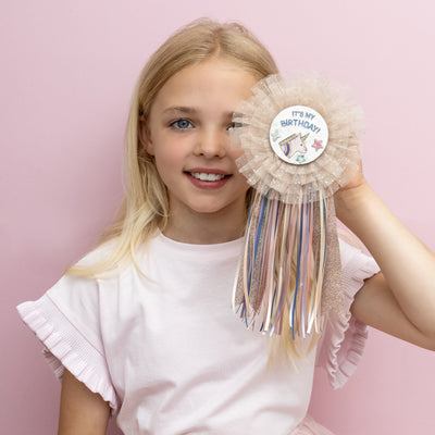 magical new unicorn birthday badge! Featuring layers of soft, glitter-speckled tulle and a colourful trail of ribbons, it’s the perfect sparkly touch for any birthday star!