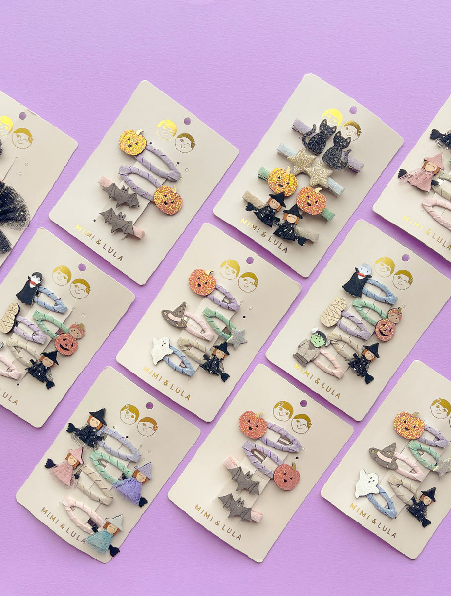 Set of Halloween-themed hair clips on display cards against a purple background