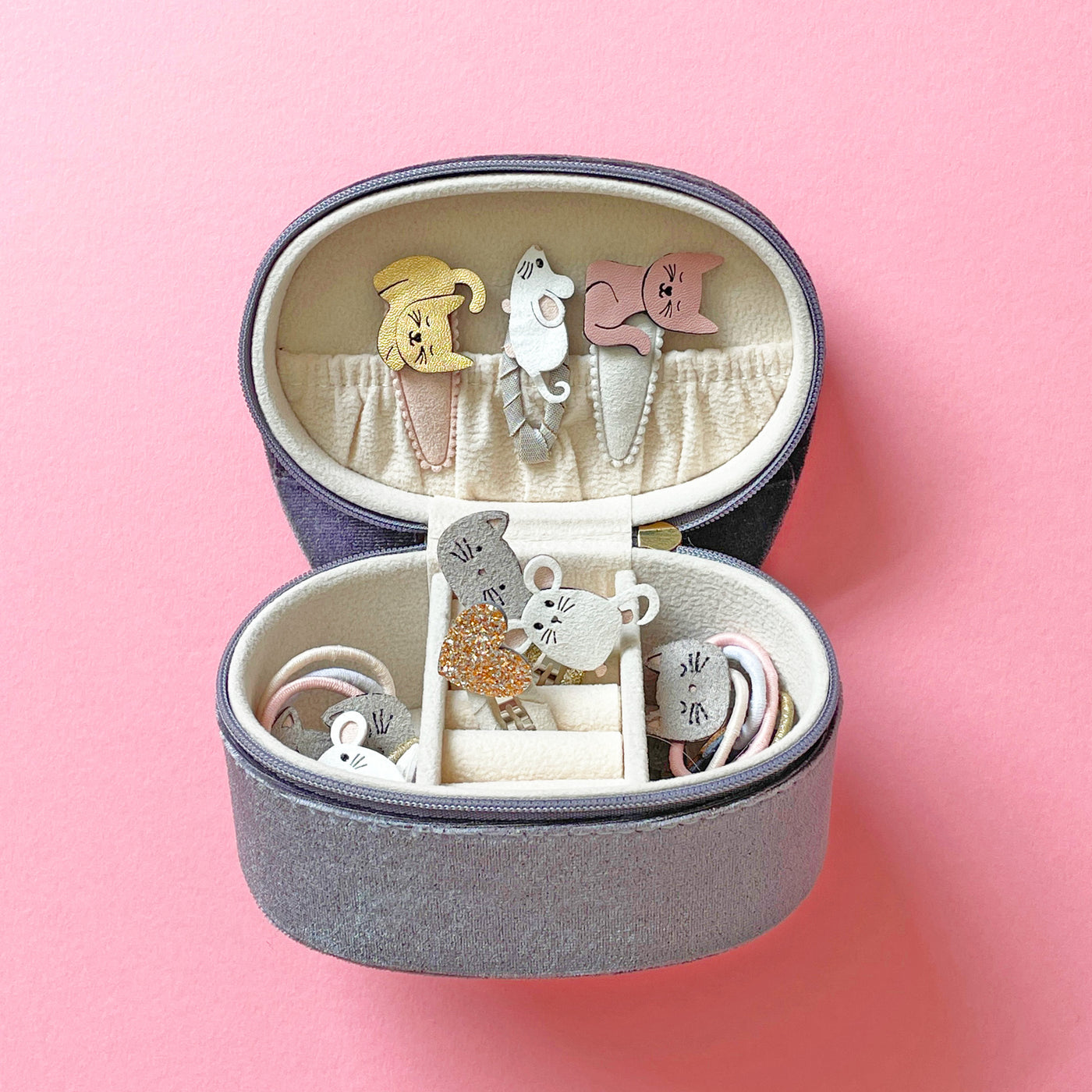 Kitty cat jewellery box with cat and mouse hair clips and accessories inside against a pink background