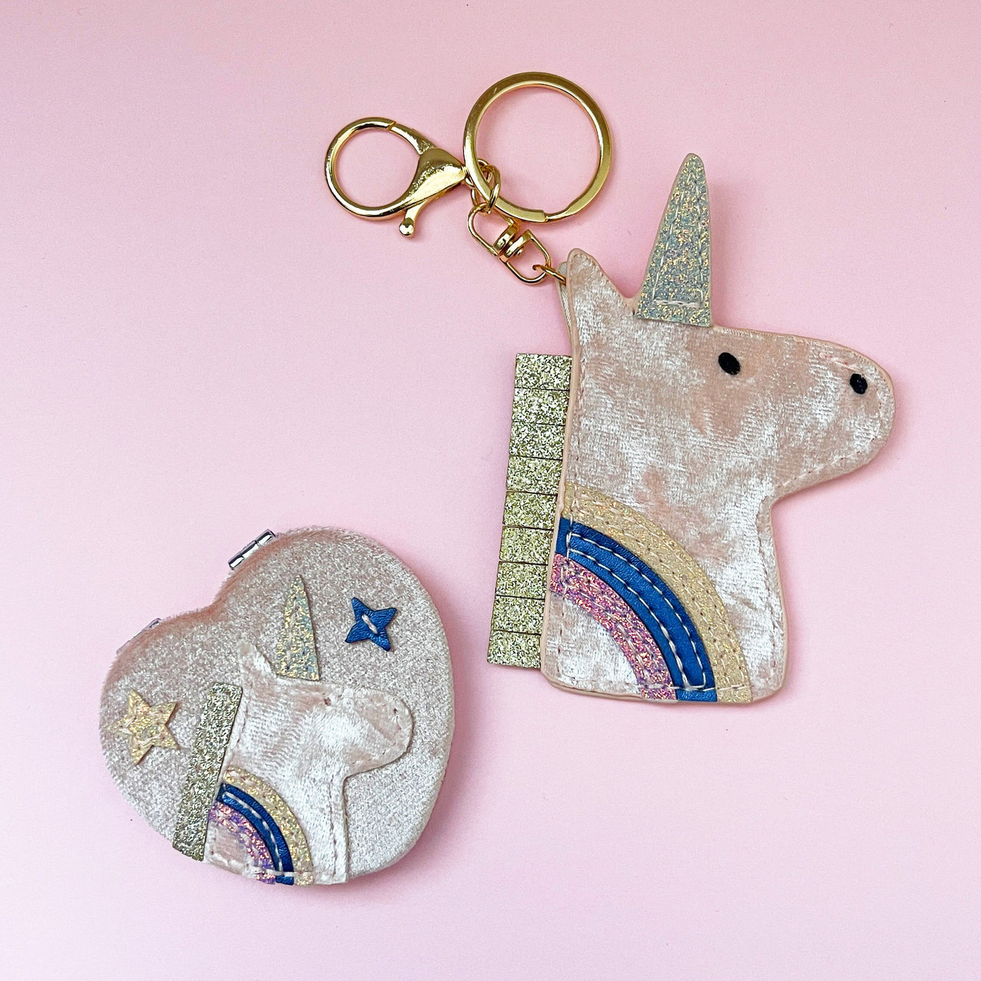 Unicorn-shaped keychain and unicorn mirror on a pink background
