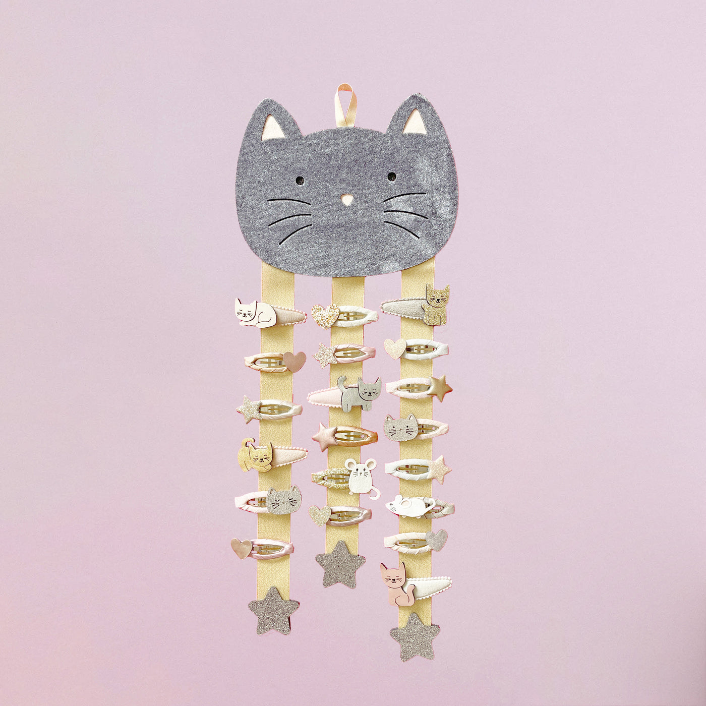 Cat hair clip hanger with hair clips attached against a pink background