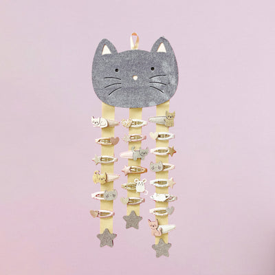 Cat hair clip hanger with hair clips attached against a pink background