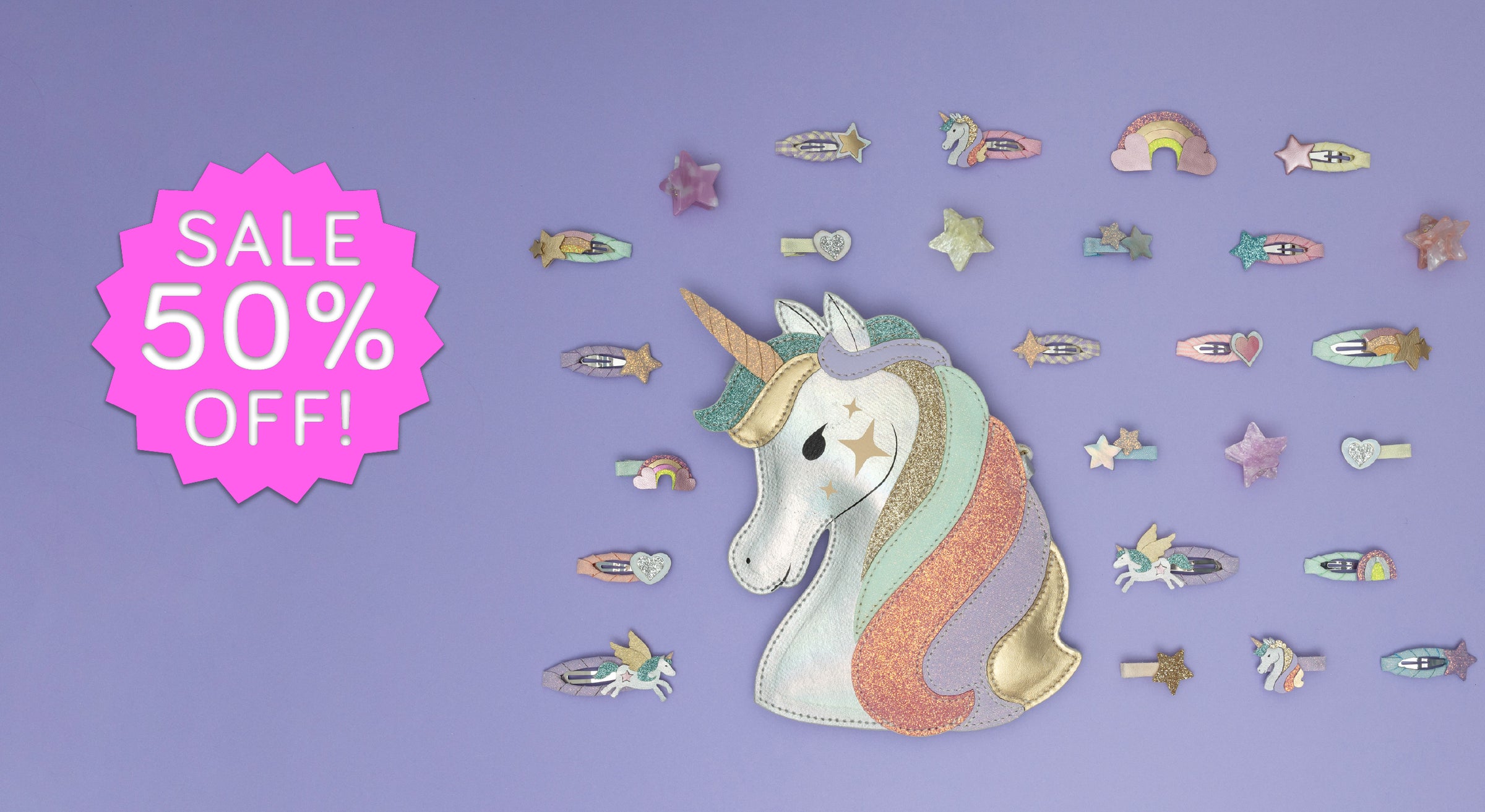 A promotional graphic on a lavender background featuring a large embroidered unicorn patch with a pink starburst badge that reads 'SALE 50% OFF!' and smaller matching unicorn-themed hair clips arranged around it.