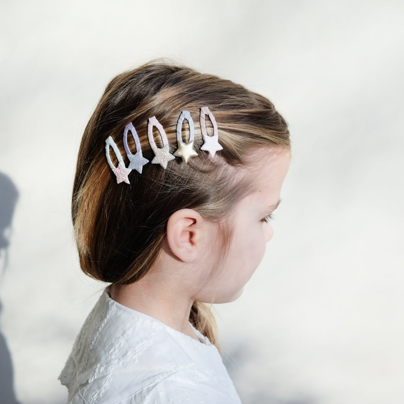 girl wearing stellina sparkle star mini clips in her hair