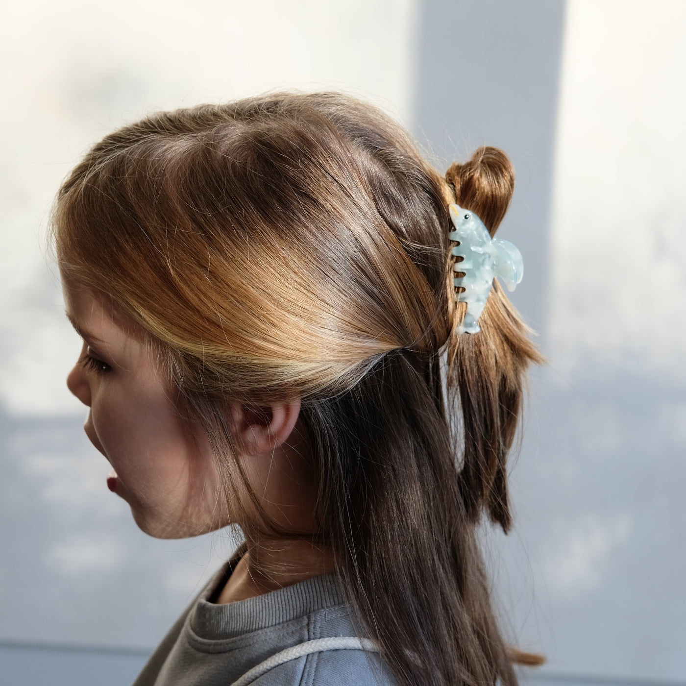 girl wearing blue dolphin claw clip in her hair