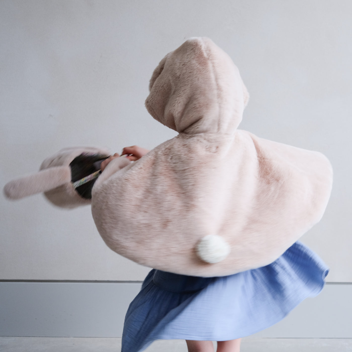 Spinning around wearing a fluffy bunny cape with hood and swinging a fluffy bunny face Easter basket