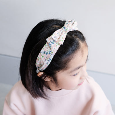 girl wearing floral edie bow alice band in her hair