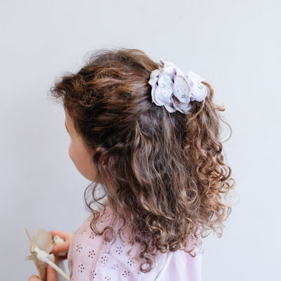 Gingham, floral print double layered scrunchie with scalloped edges worn in a part up hair style