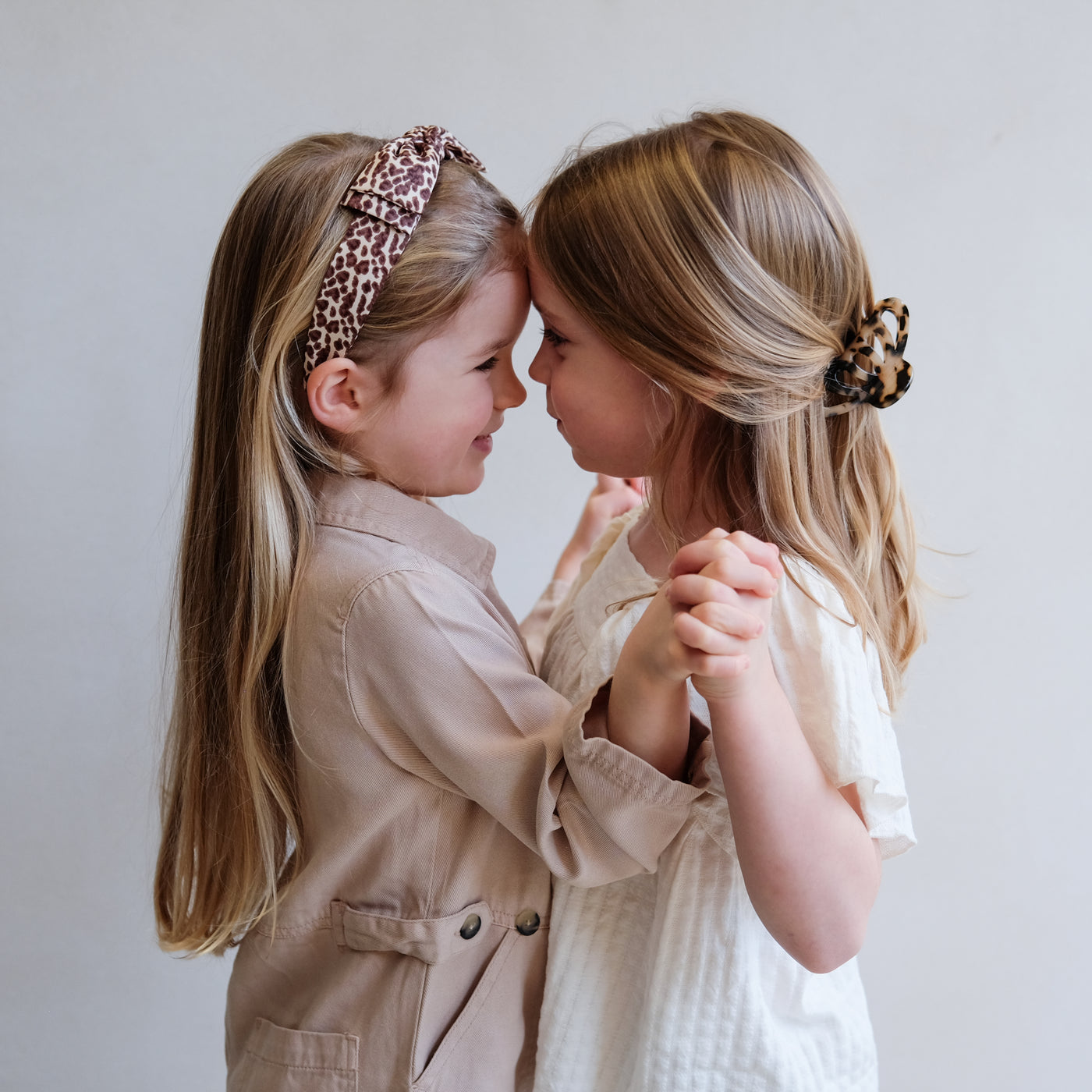 2 girls wearing leopard print hair accessories
