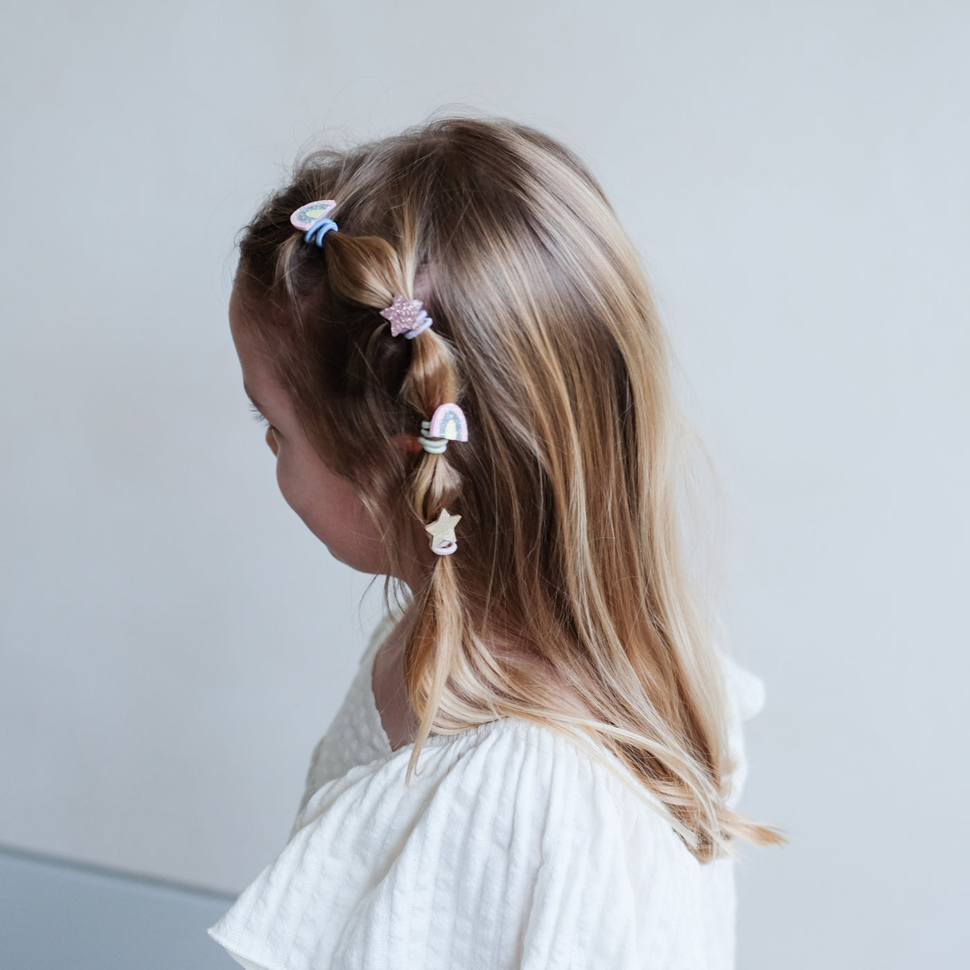 girl wearing Rainbow & star mini ponies in her hair