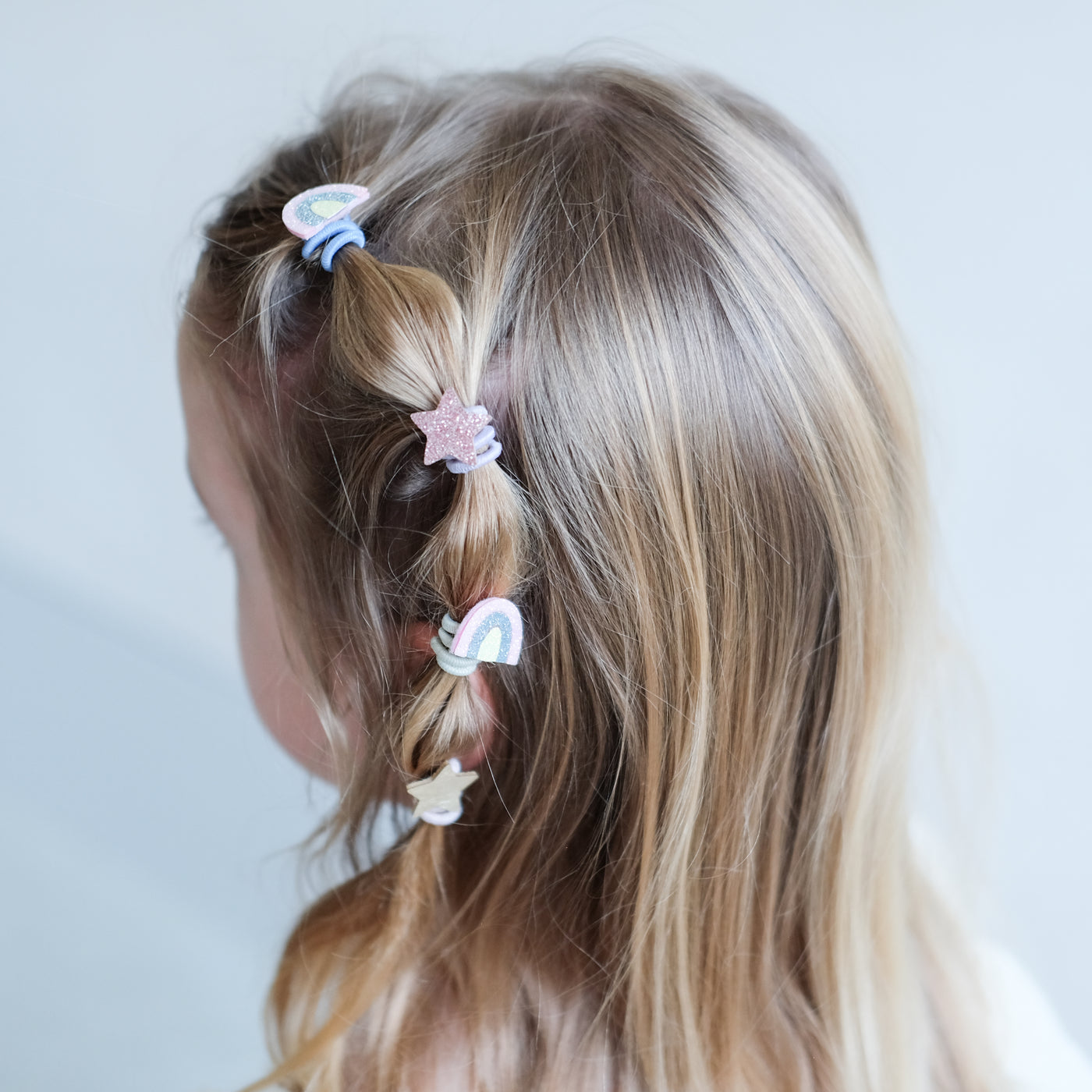 girl wearing Rainbow & star mini ponies in her hair