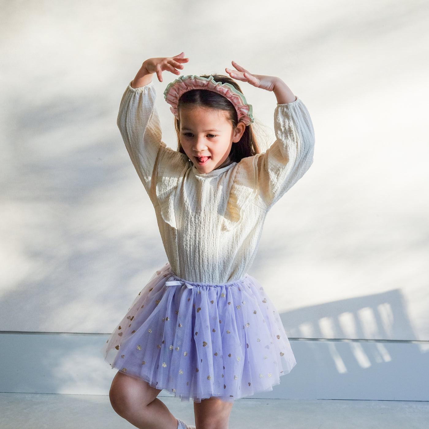 girl wearing stripe ruffle alice band and purple tutu