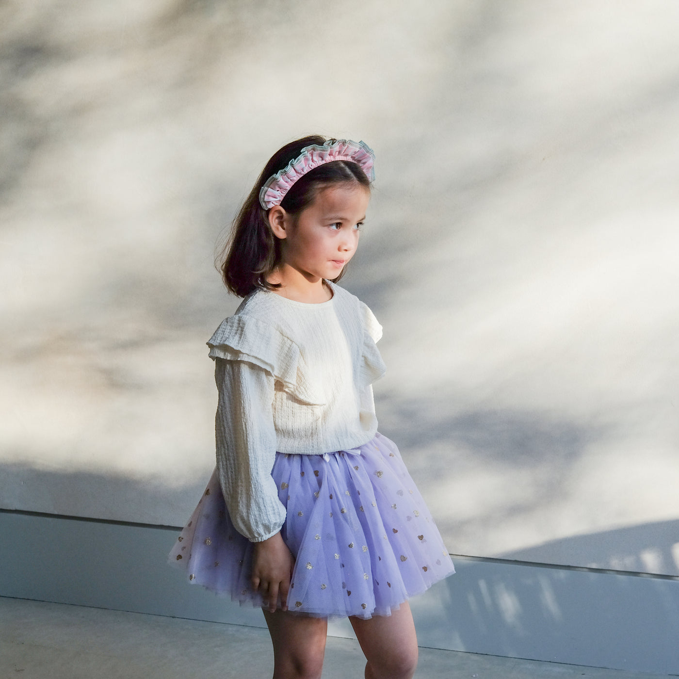 girl wearing stripe ruffle alice band and purple tutu