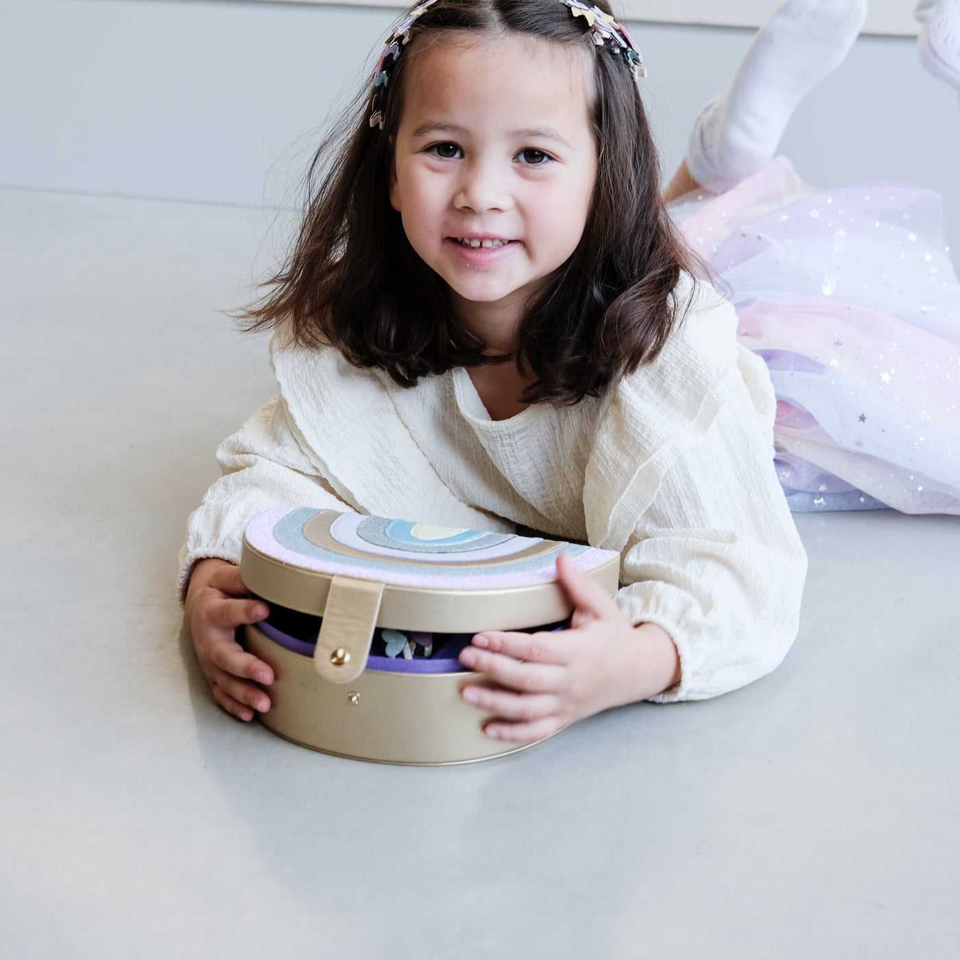 girl opening a rainbow jewellery box