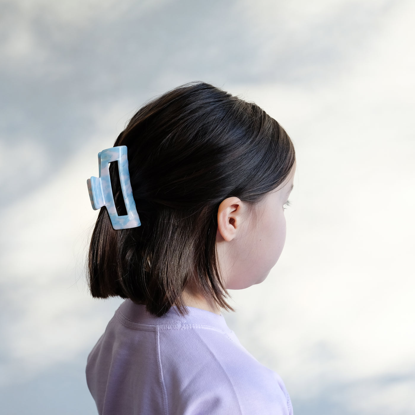 girl wearing blue acetate claw clip in hair