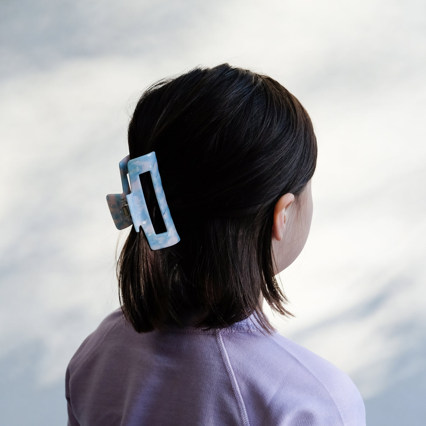 girl wearing blue acetate claw clip in hair